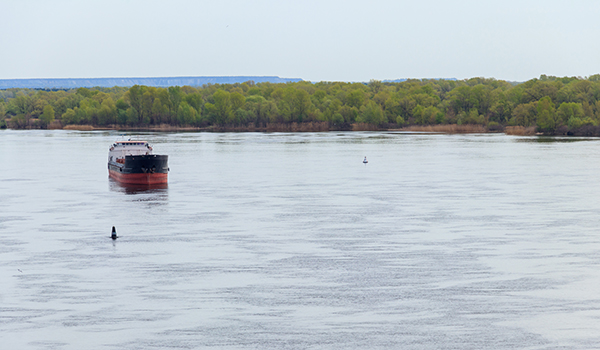 Cargo ship sailing with buoys nearby